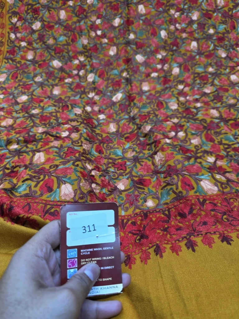 Detail of red and pink floral embroidery on mustard Pashmina fabric 311
